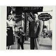 Looking south on east side of Spadina Ave. north of Dundas St., Toronto, [1947 or 1948]. Ontario Jewish Archives, Blankenstein Family Heritage Centre, item 4034.|Joseph Barsh, son of Benjamin Barsh--the owner of the Standard Barber Shop appears with his son Preston and his wife Tania in front of the Barber shop. In the background is Goldenerg's Restaurant,  Shopsowtiz' Restaurant, and the Victory Theatre.